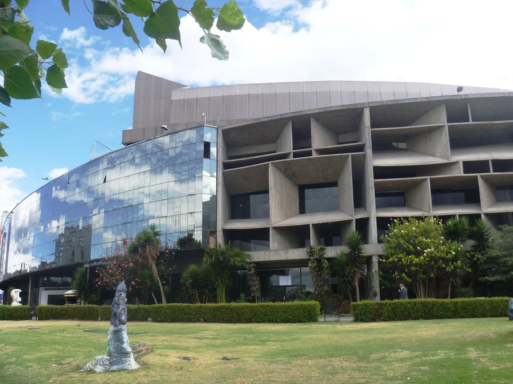 Quito's Edificio de los Espejos at the Casa de la Cultura Ecuatoriana: a curved mirrored-glass wing beside a grid of deep concrete window boxes