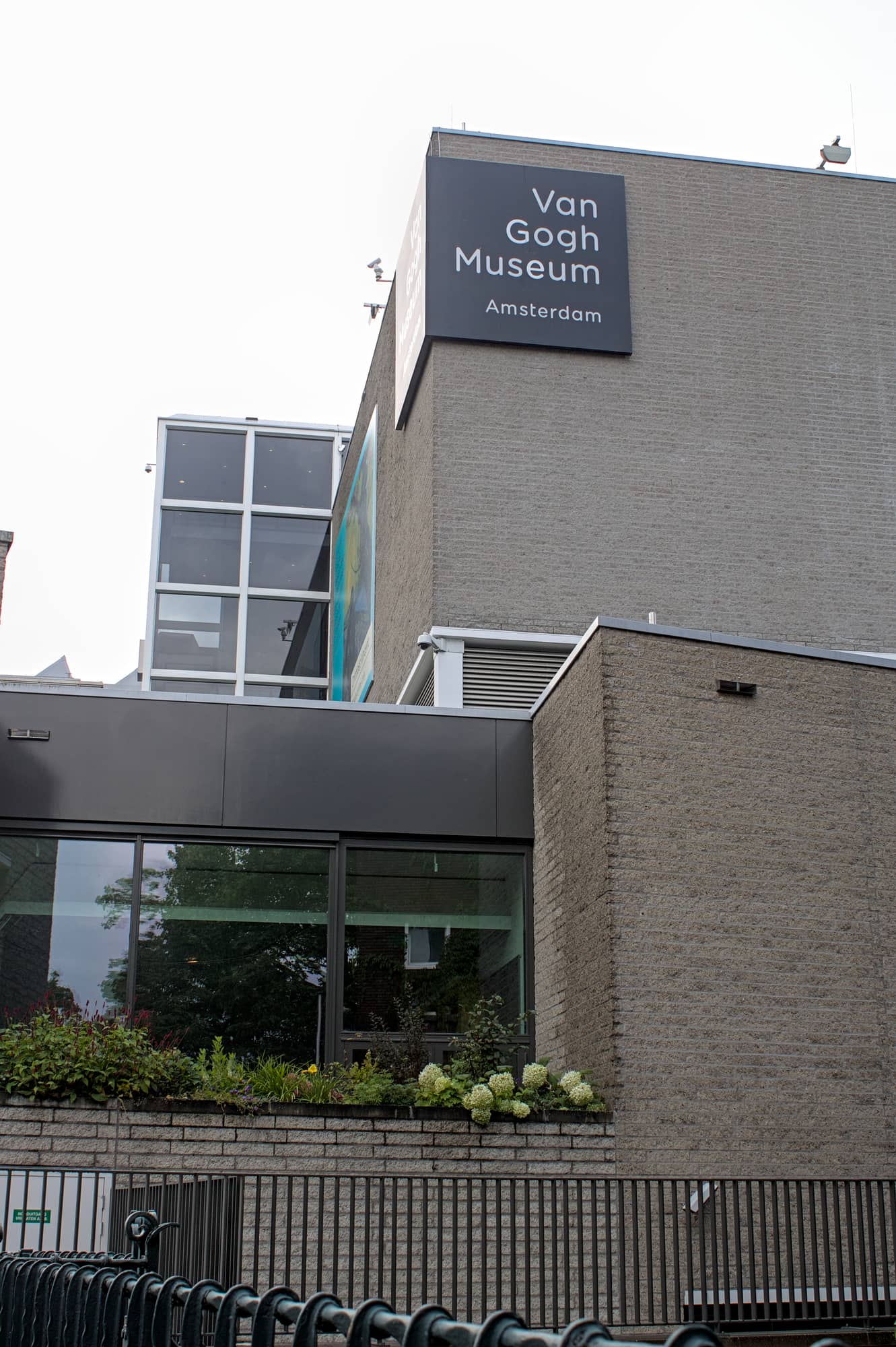 The brick volumes and glazed stair tower of Gerrit Rietveld's 1973 Van Gogh Museum building, with the museum's black sign high on the wall