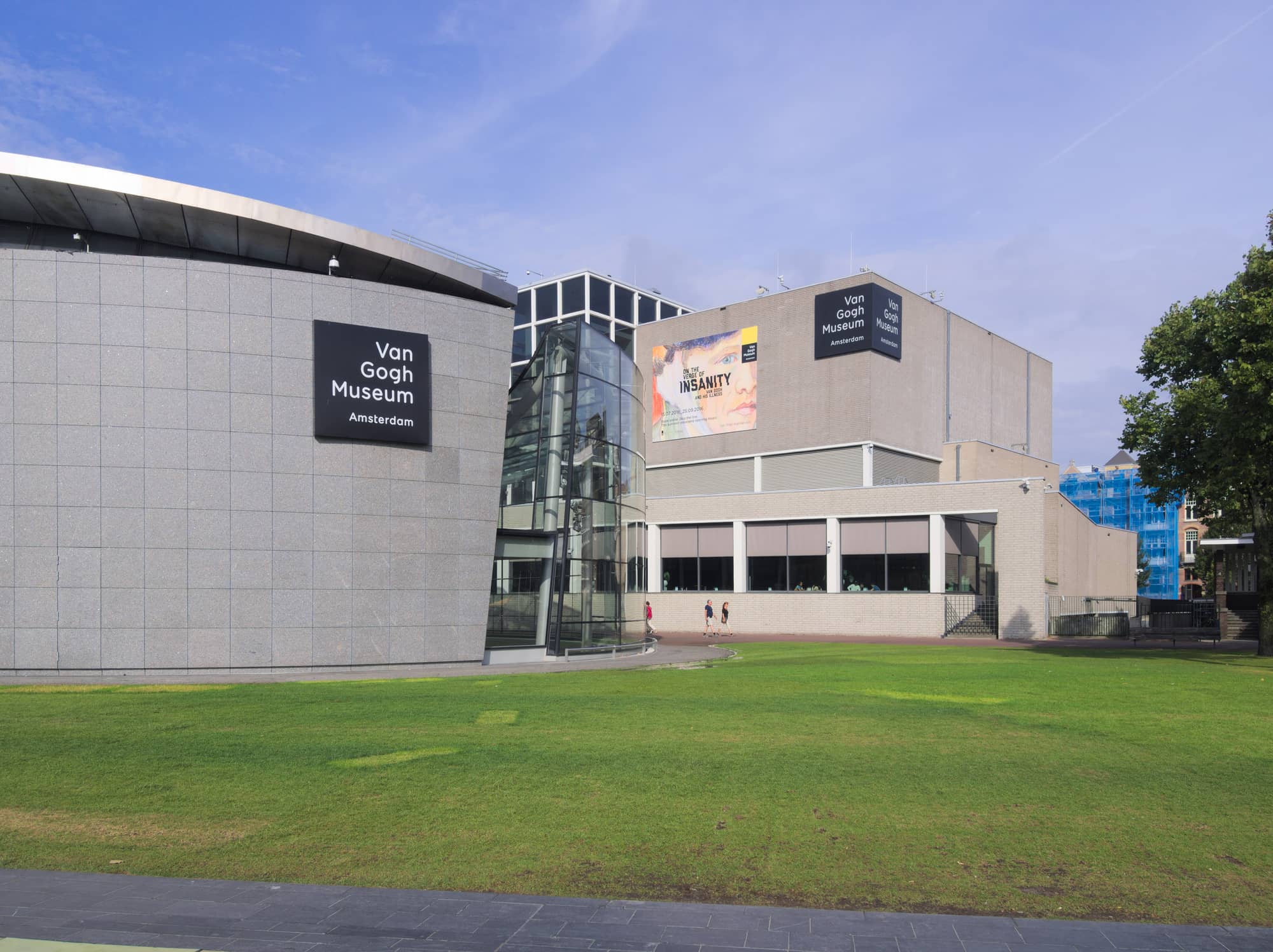 The Van Gogh Museum in Amsterdam, subject of the Van Gogh Museum renovation: the granite-clad oval of the Kurokawa wing, a glass entrance hall and the brick block of the Rietveld building across a lawn on Museumplein